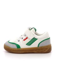 Zapatilla blanca con acentos en verde y gris, que presenta una correa de velcro, cierre de cordones y suela de goma. Materiales de cuero suave y ante texturizado.