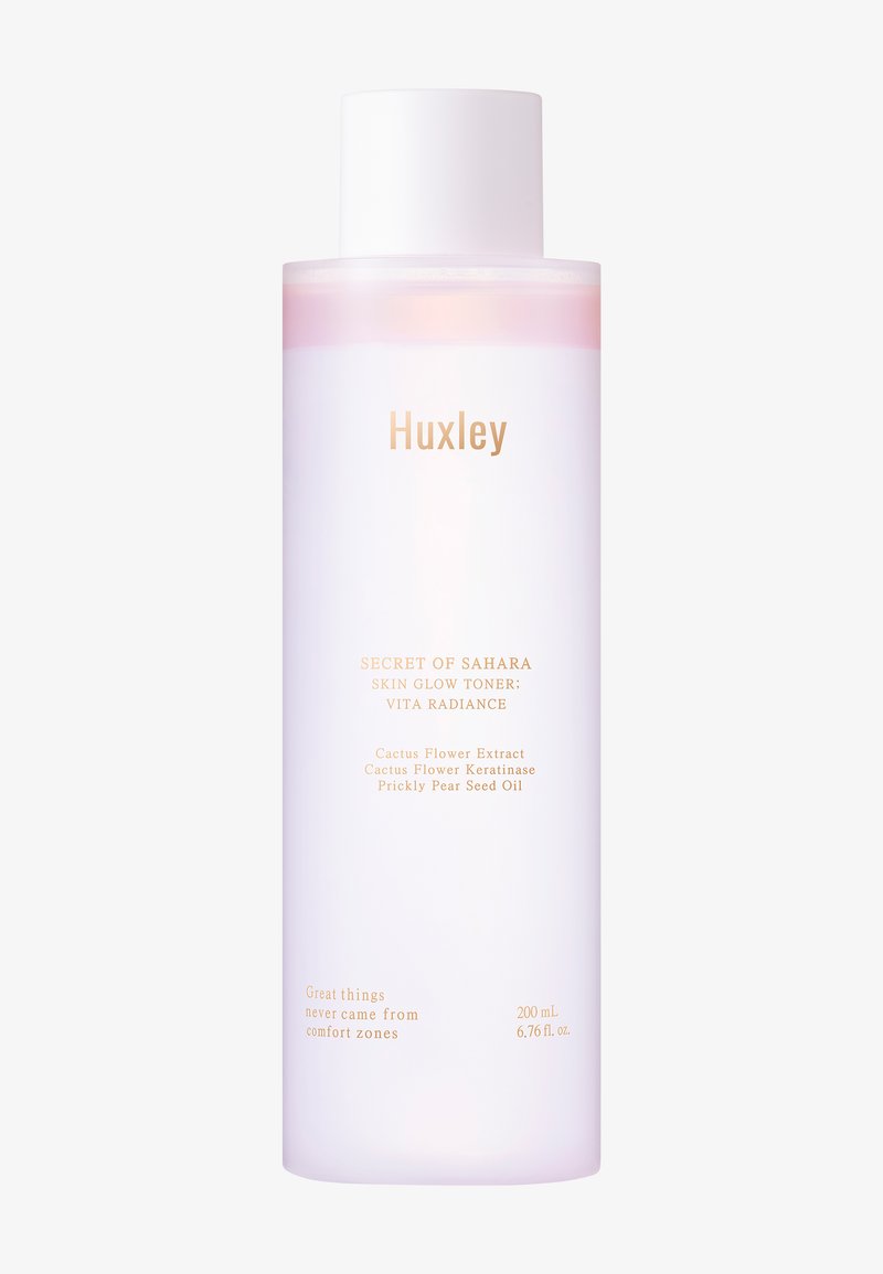 Huxley Skin Glow Toner i en genomskinlig rosa flaska med ett vitt lock. Har guldtext för produktinformation. Innehåller 200 mL.