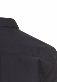 Donker shirt met korte mouwen, featuring een puntige kraag, een gladde textuur en een eenvoudig ontwerp. Zichtbare stiksels langs de schouder en nek.