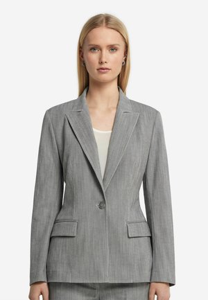 Grå blazer med et let tekstureret stof, enkelt knaplukning, notch lapels og to frontlommer. Bæres over en lys top.