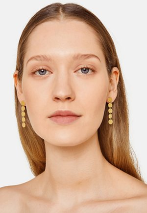 Goldene Ohrringe mit drei kreisförmigen Anhängern, die in einer linearen Anordnung nach unten hängen. Das Design zeichnet sich durch eine glatte, polierte Oberfläche aus.