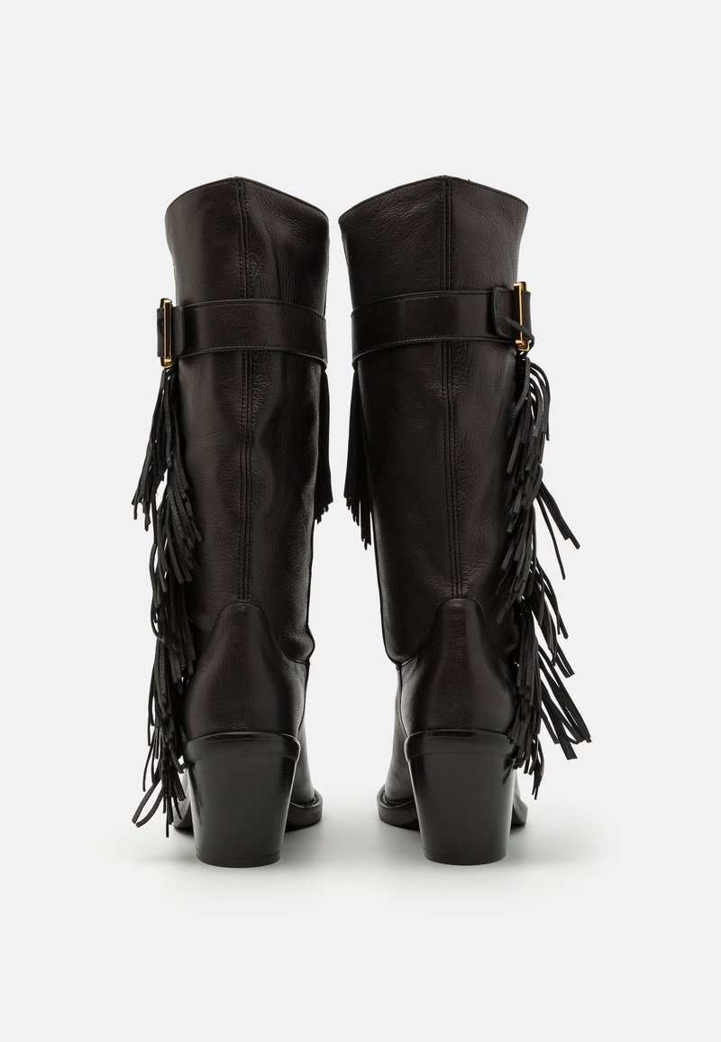 Black knee-high boots made of leather, featuring a buckle strap and fringe detailing. The heels are chunky with a smooth texture.