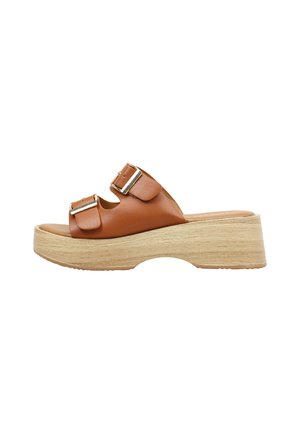 Sandalia tipo slide de cuero marrón con dos hebillas ajustables plateadas y suela plataforma gruesa de madera clara.