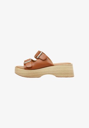 Sandalia tipo slide de cuero marrón con dos hebillas ajustables plateadas y suela plataforma gruesa de madera clara.