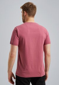 T-shirt a maniche corte e collo rotondo in cotone rosa pallido. Tessuto morbido con un pannello a contrasto nella parte superiore della schiena. Design semplice.