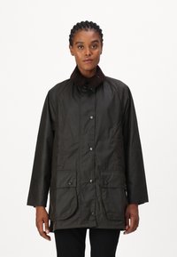 Dark brown waterproof jacket featuring a corduroy collar, front snap buttons, and two large flap pockets. Smooth texture with a relaxed fit.