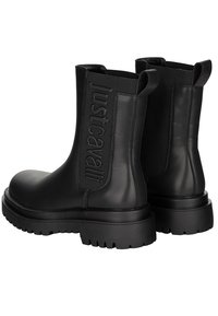 Czarne skórzane botki za kostkę z grubymi gumowymi podeszwami i pętelkami do ściągania, z napisem "Just Cavalli" wytłoczonym na bocznych panelach zewnętrznych.