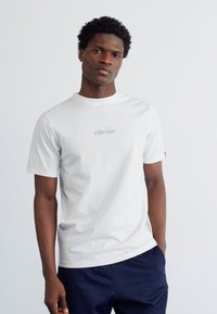 Tricou alb cu mânecă scurtă din bumbac, cu guler rotund, având un logo verde deschis pe piept. Textură netedă, croi lejer.