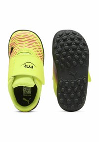 Pantofi sport galbeni strălucitori, cu accente roz și negre, având o talpă texturată și o curea Velcro pentru închidere.