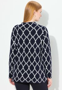 Maglione navy con motivo a diamante bianco, maniche lunghe e scollo rotondo. Tessuto a maglia con una vestibilità comoda.