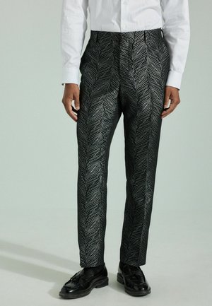 Black pants with a textured, silver leaf pattern; features a tailored fit and a crease down the front; worn with a white shirt and black shoes.