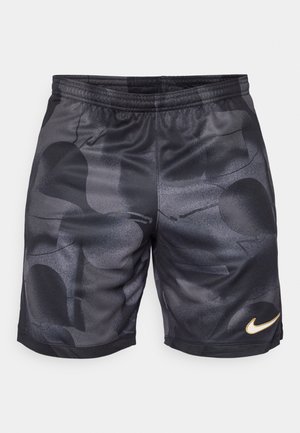 Pantalones cortos deportivos negros con un patrón geométrico texturizado y detalles de malla, con un logo dorado de Nike en la parte inferior izquierda.