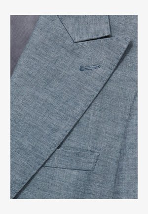 Svetlo modrý blejzer s textúrovanou látkou, s klopami a jednou kapsou; detaily prešívania zvýrazňujú dizajn.