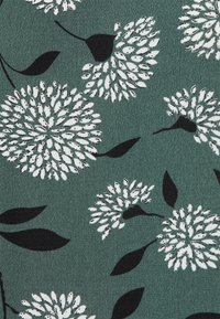 Floral fabric featuring large white and black dandelion-like flowers on a dark green textured background with black leaves.