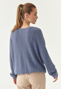 Maglione ampio a maniche lunghe in morbido knit a costine, di colore azzurro chiaro, con scollatura rotonda e tessuto testurizzato.