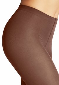 Leggings marroni senza cuciture realizzati in tessuto elasticizzato; texture liscia con un design aderente che mette in risalto la silhouette senza cuciture visibili.