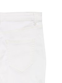 Λεπτομέρεια πίσω τσέπης σε λευκό τζιν που δείχνει θηλιά ζώνης, ραφή και περίγραμμα τσέπης σε απλό φόντο.