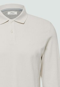 Licht beige lange mouwen polo-shirt met twee knopen, geribde kraag en subtiel s.Oliver-logo geborduurd op de linkerborst.