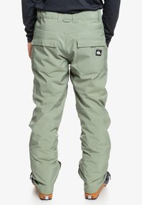 Heren sneeuwbroeken in lichtgroen, met cargopockets, versterkte knieën en een logo patch op de achterkant. Gemaakt van duurzaam, weersbestendig materiaal.