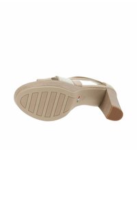 Sandal in beige con tacco alto, con una fascia testurizzata, un tacco robusto e una suola rigata. Caratterizzato da linee pulite e una finitura in materiale liscia.