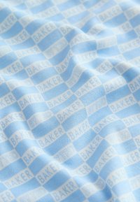 Svetlomodrá tkanina s opakujúcim sa kockovaným vzorom a bielym textom "BAKER" a "TED", vytvárajúca jemnú textúru a dizajn.