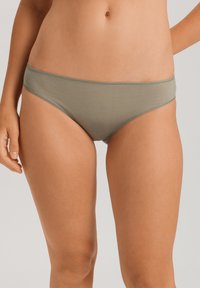 Grön bomullsbikiniunderdel med en slät textur, låg midja och kontrasterande trim runt midjebandet och benöppningarna.