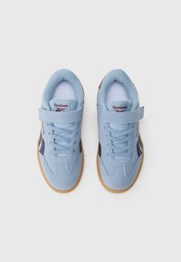 Light blue sports shoes with a suede upper, featuring a Velcro strap and lace closure, brown gum rubber outsole, and blue fabric accents.