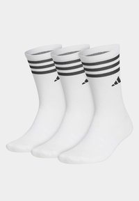 Tres pares de calcetines deportivos blancos con franjas negras en la parte superior y un logo negro, fabricados con una tela elástica para mayor comodidad.