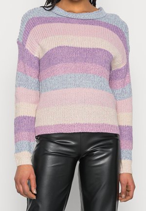 Pull en tricot à larges rayures horizontales lavande, rose, crème et bleu clair, porté avec un pantalon en cuir noir.