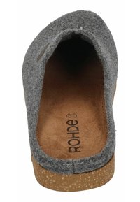 Pantufla de fieltro gris con punta redondeada, suela de corcho y detalles de costura mínimos. El interior presenta una superficie marrón texturizada con marca.