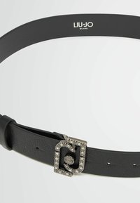 Schwarzer Leder Gürtel mit strukturiertem Finish, rechteckige silberne Schnalle verziert mit klaren Strasssteinen, mit dem eingravierten Markennamen "LIU-JO".