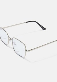 Ochelari de metal pătrați cu rame argintii, lentile clare și brațe din plastic negru, având un design minimalist și accente subtile.