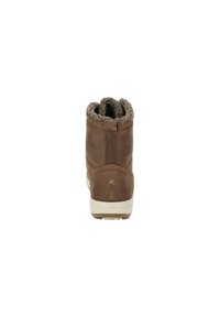 Braune Leder-Stiefelette mit einem strukturierten braunen Fellfutter, flacher cremefarbener Sohle und einem kleinen Logoakzent nahe der Ferse.