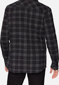 Zwart en grijs geruit flanellen shirt met een kraag, lange mouwen en knoopmanchetten. Zachte textuur, gebogen zoom en achterkant met yoke detail.