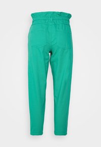 Calças verdes em algodão com cintura elástica, apresentando dois bolsos traseiros e um design de perna afunilada. Textura suave e estilo casual.