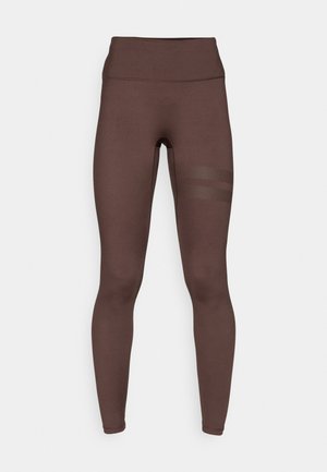 Bruine legging met een hoge tailleband, gemaakt van een glad, rekbaar materiaal, met mesh stroken aan de zijkant.