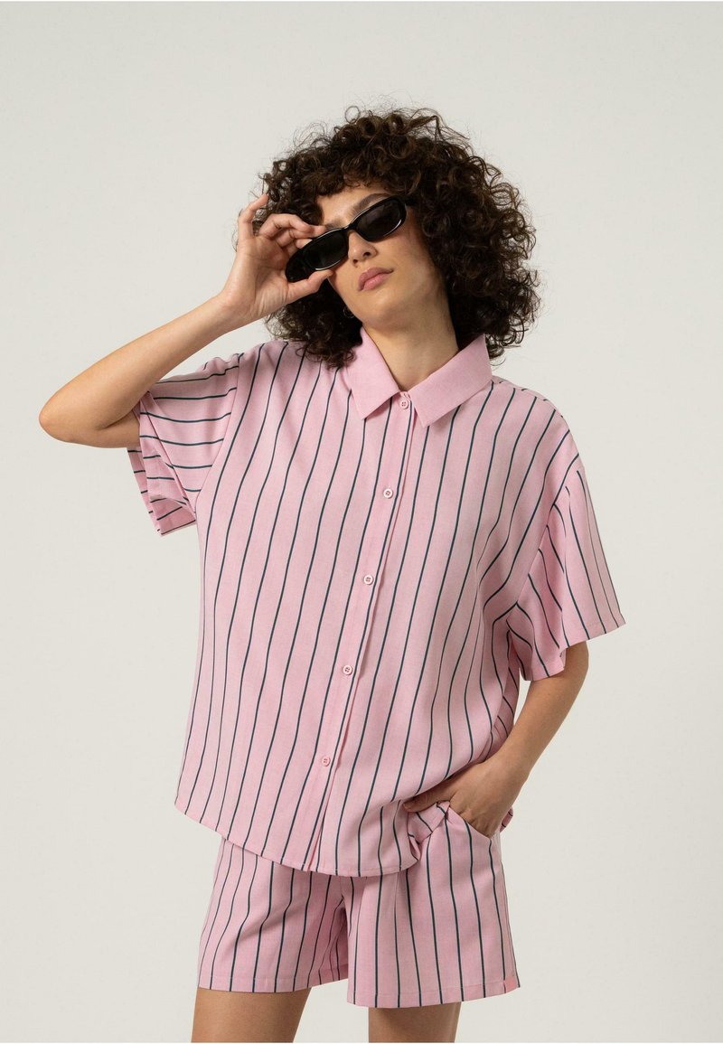 Rosa kortermet skjorte med vertikale marineblå striper, knappenedfront og krage, kombinert med matchende rosa shorts med lommer.
