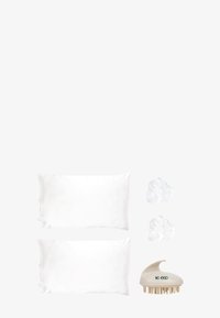 Due federe in raso bianco, due scrunchies bianchi e un massaggiatore per cuoio capelluto ecologico beige con testo verde di lato.