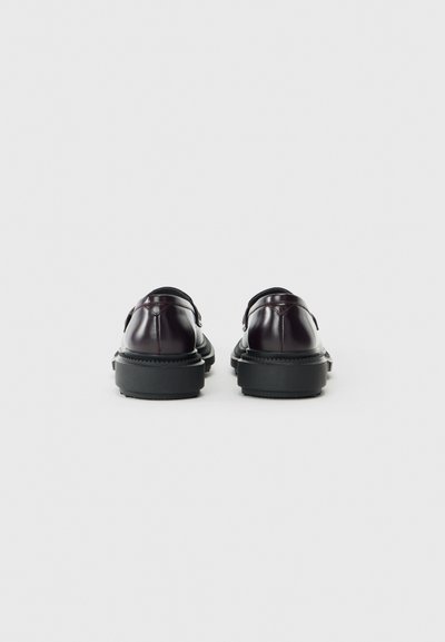 Scarpe in pelle bordeaux scuro con finitura liscia, punta arrotondata e suola in gomma nera. Vista posteriore che mostra dettagli cuciti e un design minimale.