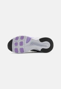 Sole sportovní obuvi Nike s texturovanou černou gumovou patou, světle šedým mezipodešvem s levandulovými akcenty a vzorovanými zónami trakce.