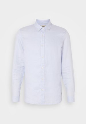 Chemise en lin bleu clair avec manches longues, col boutonné, fermeture par boutons sur le devant et texture lisse. Présente des détails tissés subtils.