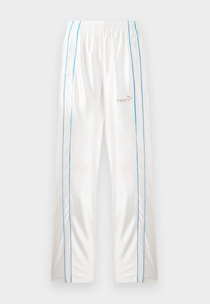 Valkoiset verkkohousut, joissa on kuminauha vyötäröllä, siniset sivut vetskareilla, ja beige "Fenty" ja Puma -logot oikeassa etujalkassa.