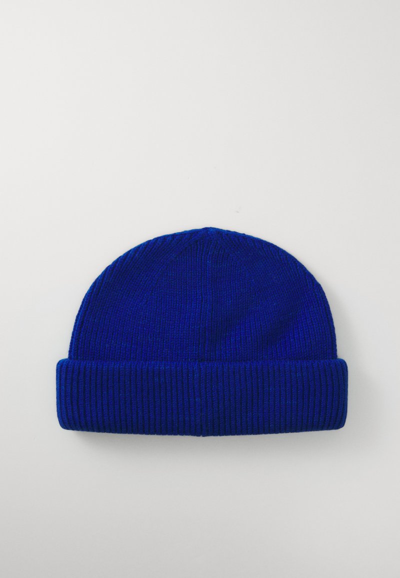 Blauwe gebreide beanie met een geribde textuur en opgerolde rand, gemaakt van zacht garen, zonder patronen of accenten, in een effen kleur.