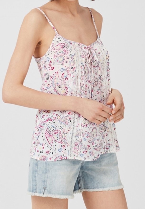 Top sin mangas con estampado floral y delicados tirantes, que presenta detalles texturizados. Combina con pantalones cortos de denim claros, diseño casual y aireado.
