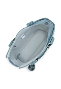 Light blue fabric bag with a zip closure, featuring a soft interior, side pockets, and a fluffy pom-pom accent. Brand label visible inside.