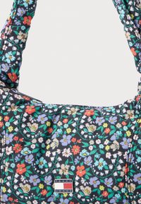 Torba na ramię w kwiatowy wzór na ciemnym tle z kolorowymi kwiatami. Wykonana z nylonu, wyposażona w podwójne uchwyty i metalową zawieszkę z logo.