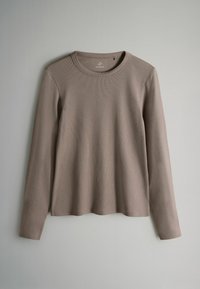 Pruun pikka varrukas ribakujuline topp, millel on ümar kaelus ja lõdva lõikega disain, millel on sile tekstuur ja peened õmblused.