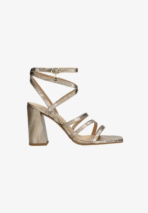 Riemchen-High-Heelsandale in metallisch Gold mit einem strukturierten Schlangenledermuster. Verfügt über eine quadratische Zehenpartie und einen klobigen Blockabsatz.