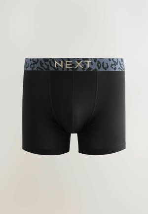 Black boxer briefs with a leopard-print waistband in gray and blue, featuring the brand name "NEXT" in gold lettering. Smooth fabric texture.