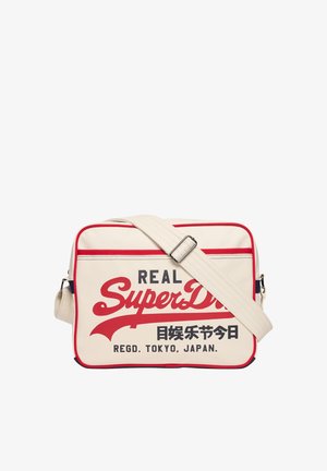 Beige rechthoekige schoudertas met rode bies en verstelbare band, met de tekst "Real SuperDry" en Japanse tekens aan de voorkant.